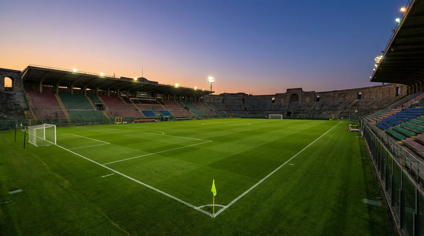 Veduta serena di uno stadio di calcio vuoto con il prato verde curato e le tribune illuminate al crepuscolo