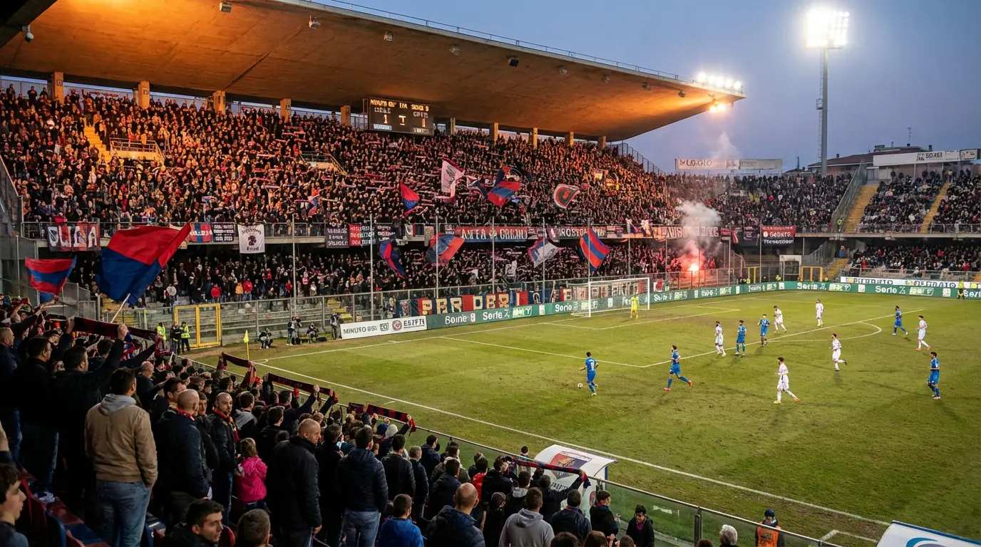Tifosi sugli spalti di uno stadio di Serie B che esultano durante una partita serale
